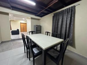 a dining room with a table and chairs and a refrigerator at Santai De Lui Resorts in Kampong Mesjid