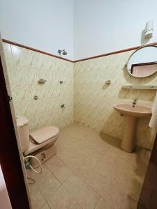 a bathroom with a toilet and a sink at Funky Hotel in Hikkaduwa