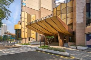 Renaissance Kuala Lumpur Hotel & Convention Centre في كوالالمبور: مبنى كبير أمامه مظلة كبيرة