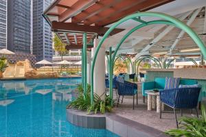 una piscina con sillas azules y mesas junto a un edificio en Renaissance Kuala Lumpur Hotel & Convention Centre, en Kuala Lumpur