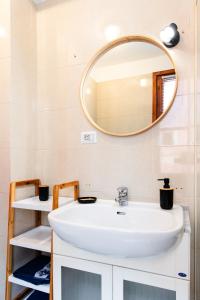 a bathroom with a white sink and a mirror at [Centro-Storico] Tutto a 2 passi in Rapallo +8 photos
