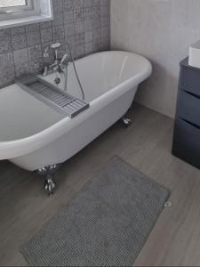 a white bath tub in a bathroom with a rug at Millies Holiday Home in Blackpool