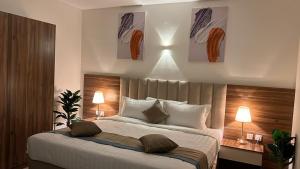 اجنحة بيادر السكنية في المدينة المنورة: غرفة نوم بسرير كبير فيها مصباحين