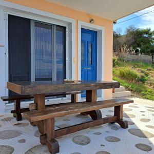 a picnic table in front of a house with a blue door at Ithaca in Perdika