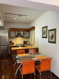 a kitchen with a table and orange chairs in it at Machi's Apartment in Markopoulo