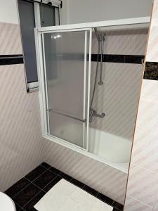 a shower with a glass door in a bathroom at Machi's Apartment in Markopoulo