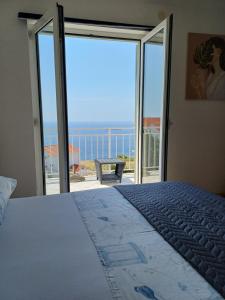 a bedroom with a bed and a view of the ocean at Apartments Joy in Cavtat
