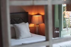 ein Schlafzimmer mit einem Bett mit einer Lampe und einem Fenster in der Unterkunft La Indiana de Begur, Petit Hotel Boutique in Begur