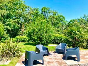 quatro cadeiras e uma mesa num jardim em Caporizon - Villa Puy d'Aiguillon- Piscine - 6 personnes 