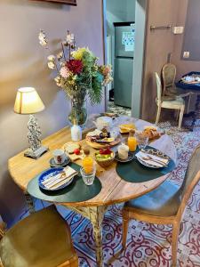 una mesa con comida y un jarrón de flores en La Indiana de Begur, Petit Hotel Boutique en Begur