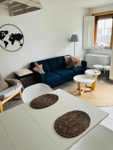 ein Wohnzimmer mit einem blauen Sofa und Tischen in der Unterkunft Duinenzicht II De Haan in De Haan