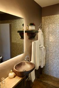 a bathroom with a sink and a mirror and towels at La Indiana de Begur, Petit Hotel Boutique in Begur
