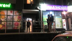 zwei Menschen, die nachts vor einem Laden stehen in der Unterkunft Lux апартаменты ЖК 7я in Astana