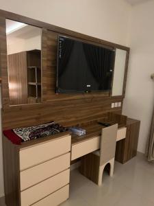 a room with a desk with a tv and a mirror at اجنحة بيادر السكنية in Medina