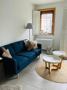 a living room with a blue couch and a table at Duinenzicht II De Haan in De Haan