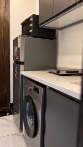 una cocina con lavadora bajo una barra en اجنحة بيادر السكنية en Medina
