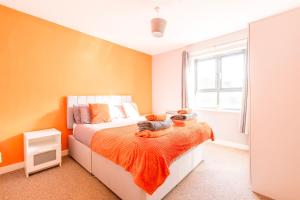 a bedroom with a bed with orange walls and a window at PRIMEEE LOCATION - Modern Central Apartment in Bristol