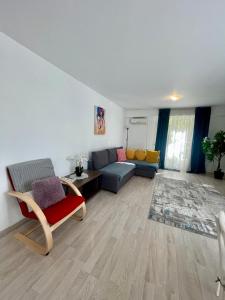 ein Wohnzimmer mit einem Sofa und einem Tisch in der Unterkunft Fly Airport Residences & Therme-SELF CHECK-IN in Otopeni