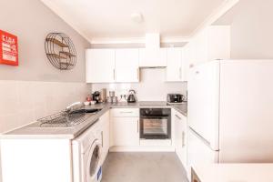 a white kitchen with white cabinets and a dishwasher at PRIMEEE LOCATION - Modern Central Apartment in Bristol