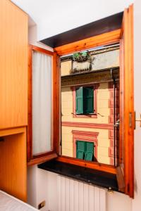 ein Fenster mit Blick auf ein Gebäude mit grünen Rollläden in der Unterkunft [Centro-Storico] Tutto a 2 passi in Rapallo