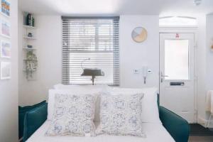 Un dormitorio con una cama con dos almohadas y una ventana. en *Central Brighton Modern Studio*, en Brighton & Hove