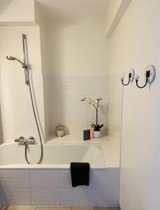 a bathroom with a bath tub with a shower at Duinenzicht II De Haan in De Haan