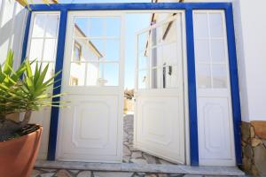 une paire de portes dans une maison dans l'établissement Dii Beach House - Casa de Férias com piscina interior aquecida, à Torres Vedras