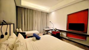 a hotel room with two beds and a flat screen tv at RED KL @ REV in Kuala Lumpur