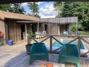 une terrasse avec deux chaises et une piscine dans l'établissement La Maison Tipasa, à Saint-Julien-en-Born