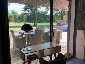 une chambre avec une table, des chaises et une lampe dans l'établissement La Maison Tipasa, à Saint-Julien-en-Born