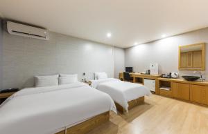 Habitación de hotel con 2 camas y lavamanos en Daesan Hotel, en Seosan