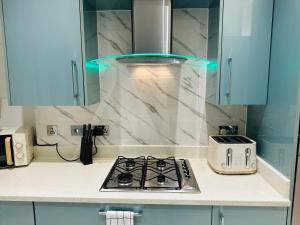 Il comprend une cuisine équipée d'une cuisinière et d'un grille-pain. dans l'établissement Bright 2 Bedroom *2 Bathroom* 10 mins to East Croydon, à Croydon