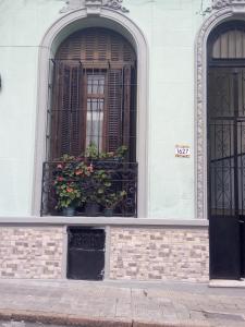 un edificio con dos ventanas con flores. en Tu casa en Montevideo, en Montevideo