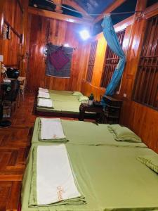 um grupo de quatro camas num quarto em Khuổi Ky Eco Homestay em Cao Bang