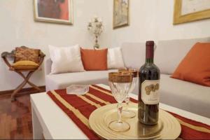 een fles wijn en een wijnglas op een tafel bij Appartamento Mira in Lucca