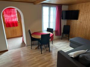 - un salon avec une table et un canapé dans l'établissement California House, à Klosters