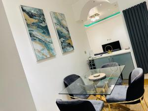 une salle à manger avec une table et des chaises en verre dans l'établissement Bright 2 Bedroom *2 Bathroom* 10 mins to East Croydon, à Croydon