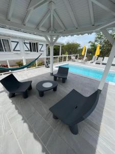 un patio con sedie e amaca accanto alla piscina di Gîtes Surya et Luna a Port-Louis