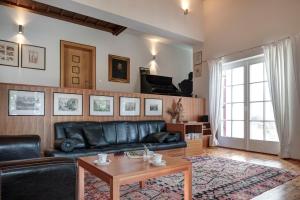 a living room with a black leather couch and a table at Landhaus Leonhard in Egna