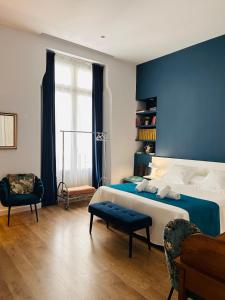 a bedroom with a large bed and a blue wall at L'Esplai Valencia in Valencia