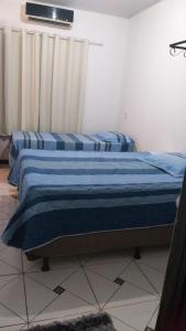 2 camas individuais num quarto com uma janela em Doce Lar - 1 suíte em Tangará da Serra
