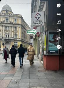 a group of people walking down a city street at Theatre55 in Sarajevo