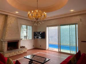 a living room with a fireplace and a chandelier at Luxury Villa at Ain-Diab in Casablanca