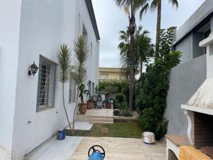 um pátio com palmeiras e um edifício branco em Luxury Villa at Ain-Diab em Casablanca