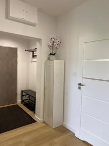 Zimmer mit einem Kühlschrank und einer Blumenvase darauf in der Unterkunft Apartament Flow in Kłodzko