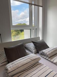 2 Betten in einem Zimmer mit einem großen Fenster in der Unterkunft Apartament Flow in Kłodzko