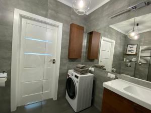 ein Badezimmer mit einer Waschmaschine und einem Waschbecken in der Unterkunft Apartament Flow in Kłodzko