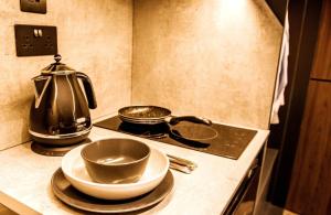 a stove top with a tea kettle and plates on it at Superior 1 Bed Studio -4D- near Royal Infirmary & DMU in Leicester