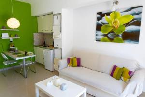 a living room with a white couch and a kitchen at Uno Apartment 2 in Livadia