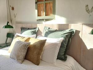 ein Bett mit Kissen darauf im Schlafzimmer in der Unterkunft Les Terrasses de Flaugnac in Flaugnac